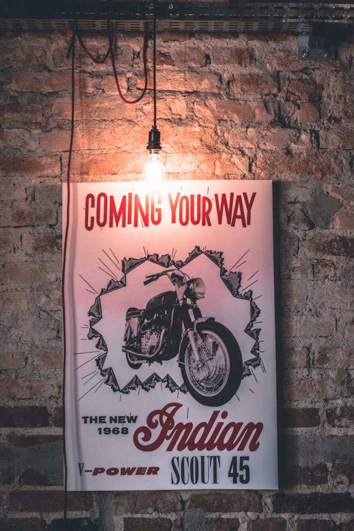 services-01 Retro 1968 Indian Scout 45 motorcycle poster with vintage bulb against brick wall.